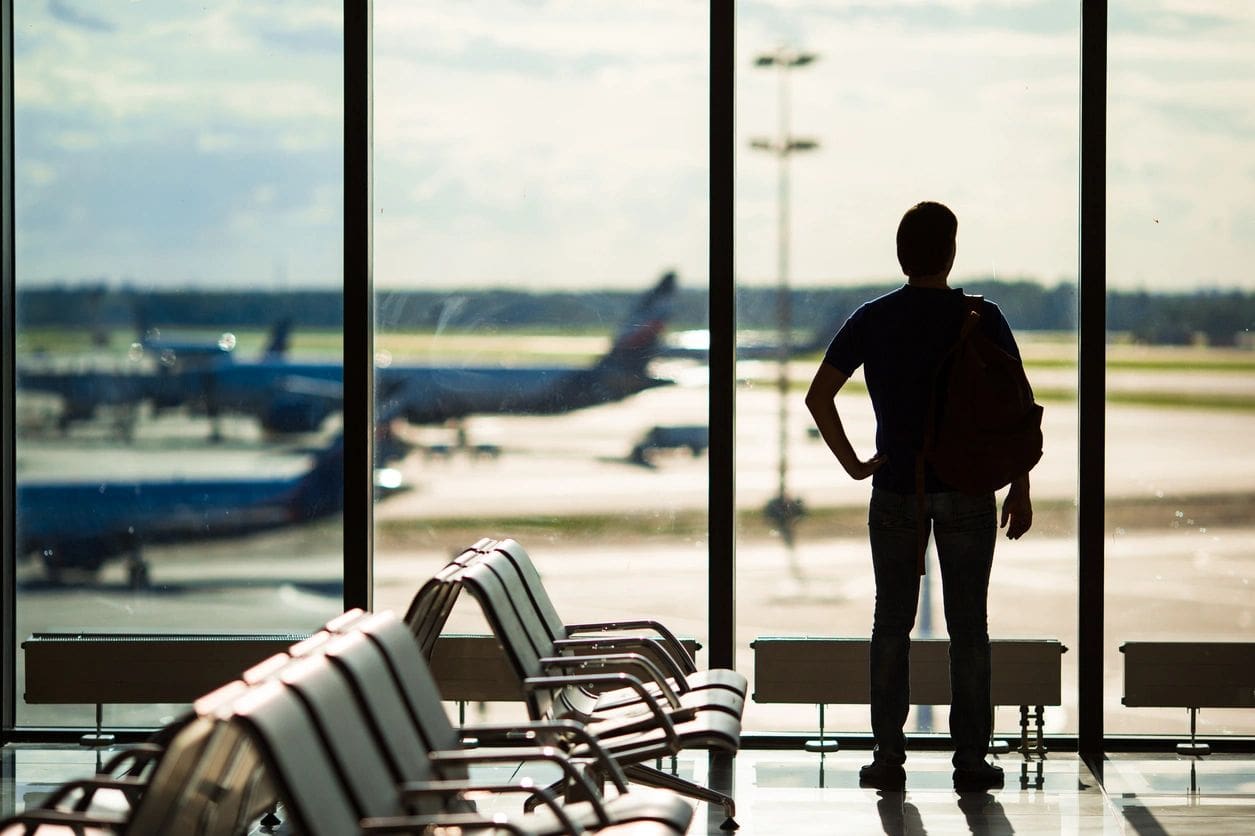 A person standing in front of an airport window.