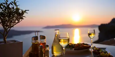 A table with wine glasses and food on it.