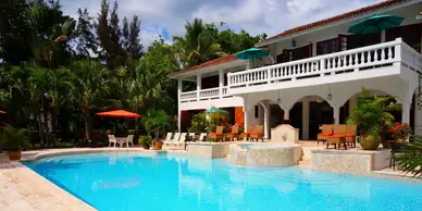 A large pool with chairs and umbrellas in the background.