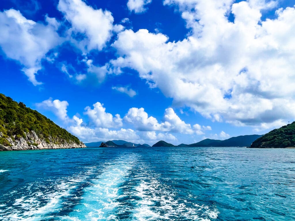 A boat sailing on the water near some mountains.