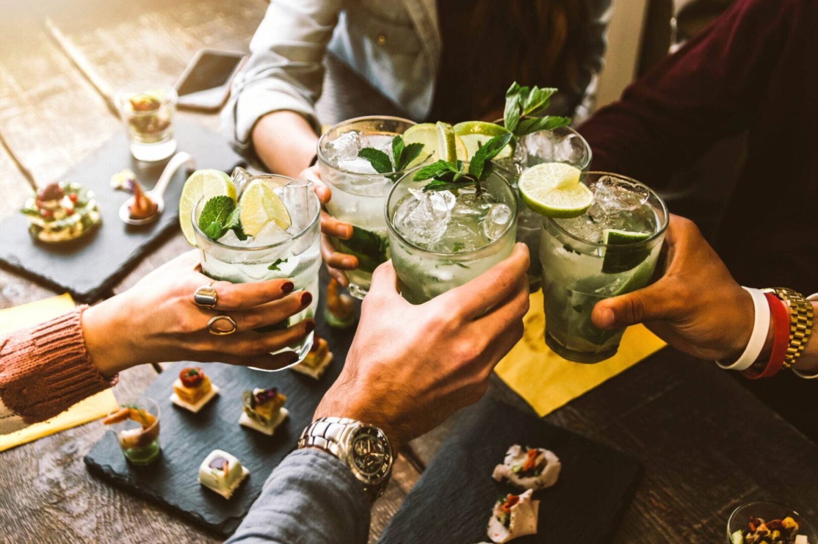 A group of people holding drinks at a table.