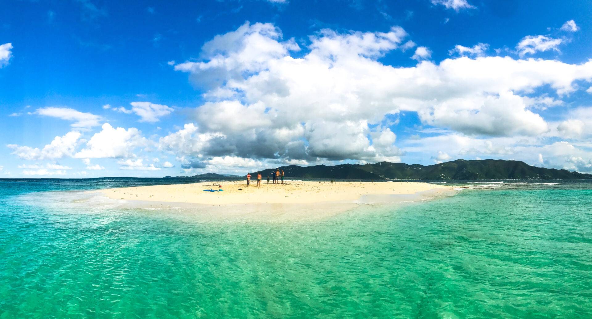 A beach with some people on it and clouds in the sky