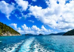 A boat sailing on the water near some mountains.