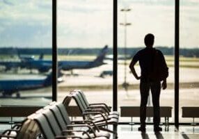 A person standing in front of an airport window.